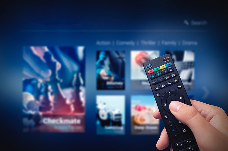 ORS streaming solutions Hand with remote control in front of smart TV screen